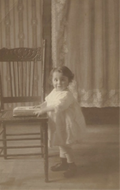 Photo of Esther as a toddler, holding book or album