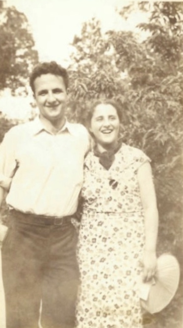 Photo of Sidney and Esther (holding a summer hat), outdoors, smiling