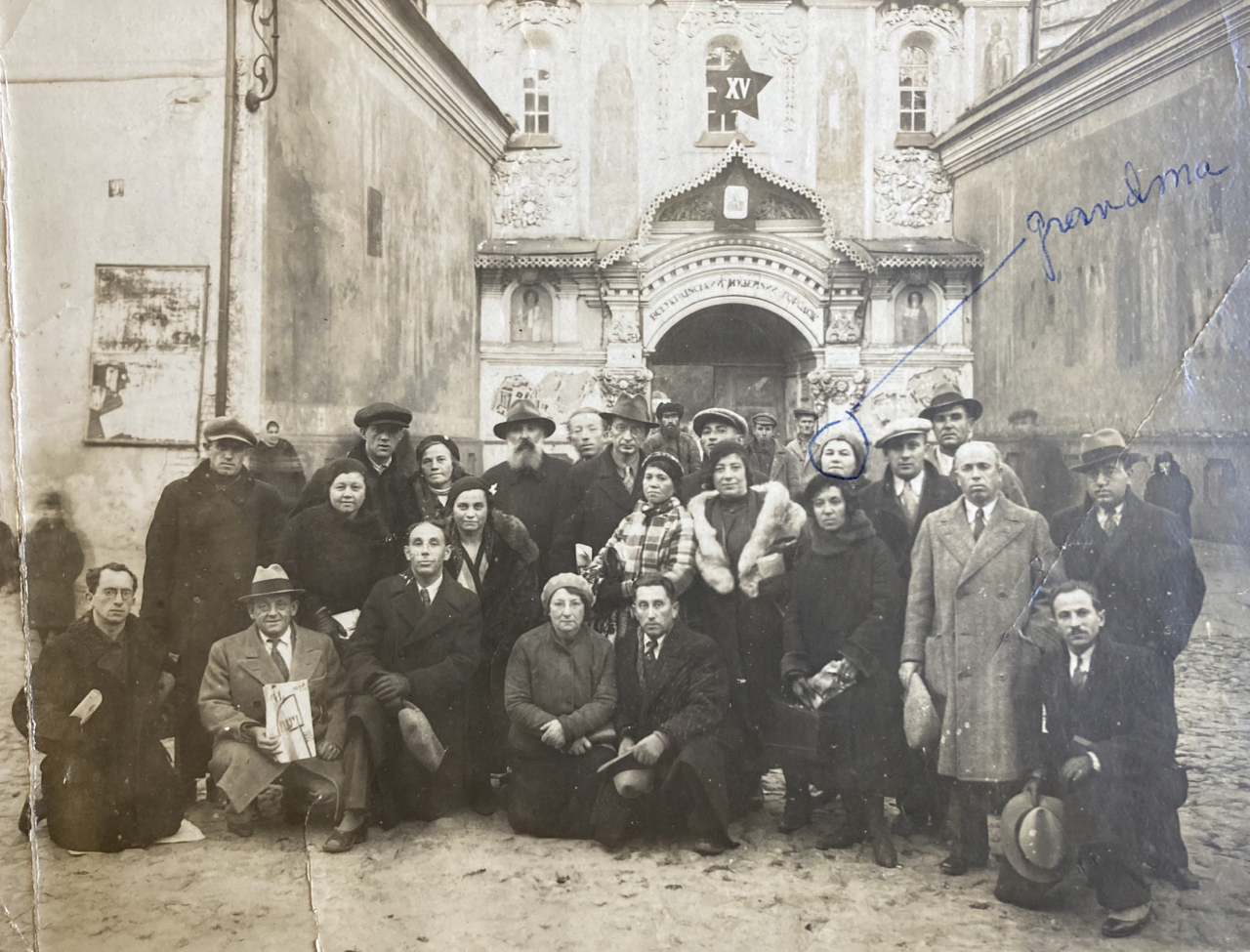Group photo of about 25 people, in coats, posing in front of an ornate building; Sonia is circled; handwriting says 