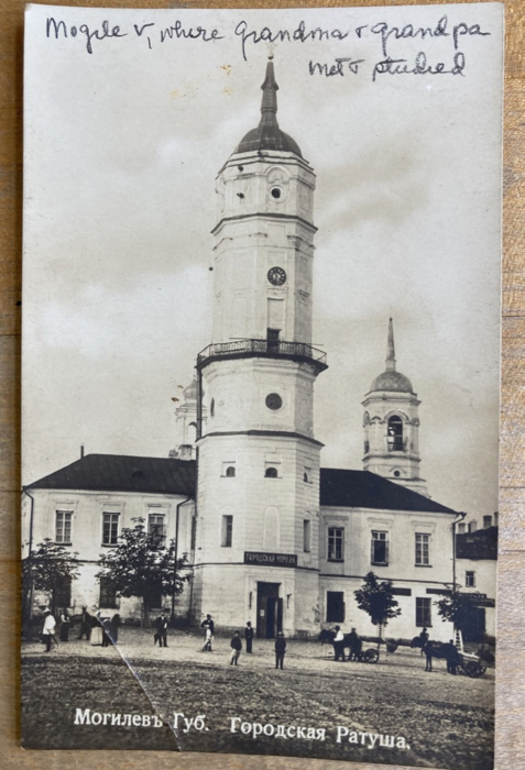 black and white postcard showing a building and people, with cyrillic characters; handwriting says 'Mogilev, where Grandma & Grandpa met and studied