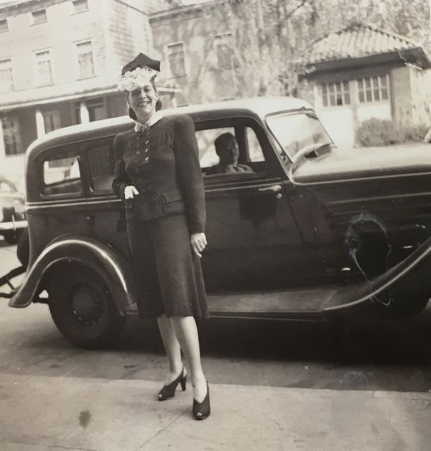 photo of Ruth (Schwartz) Black, posing in street with Joe Black in car behind her